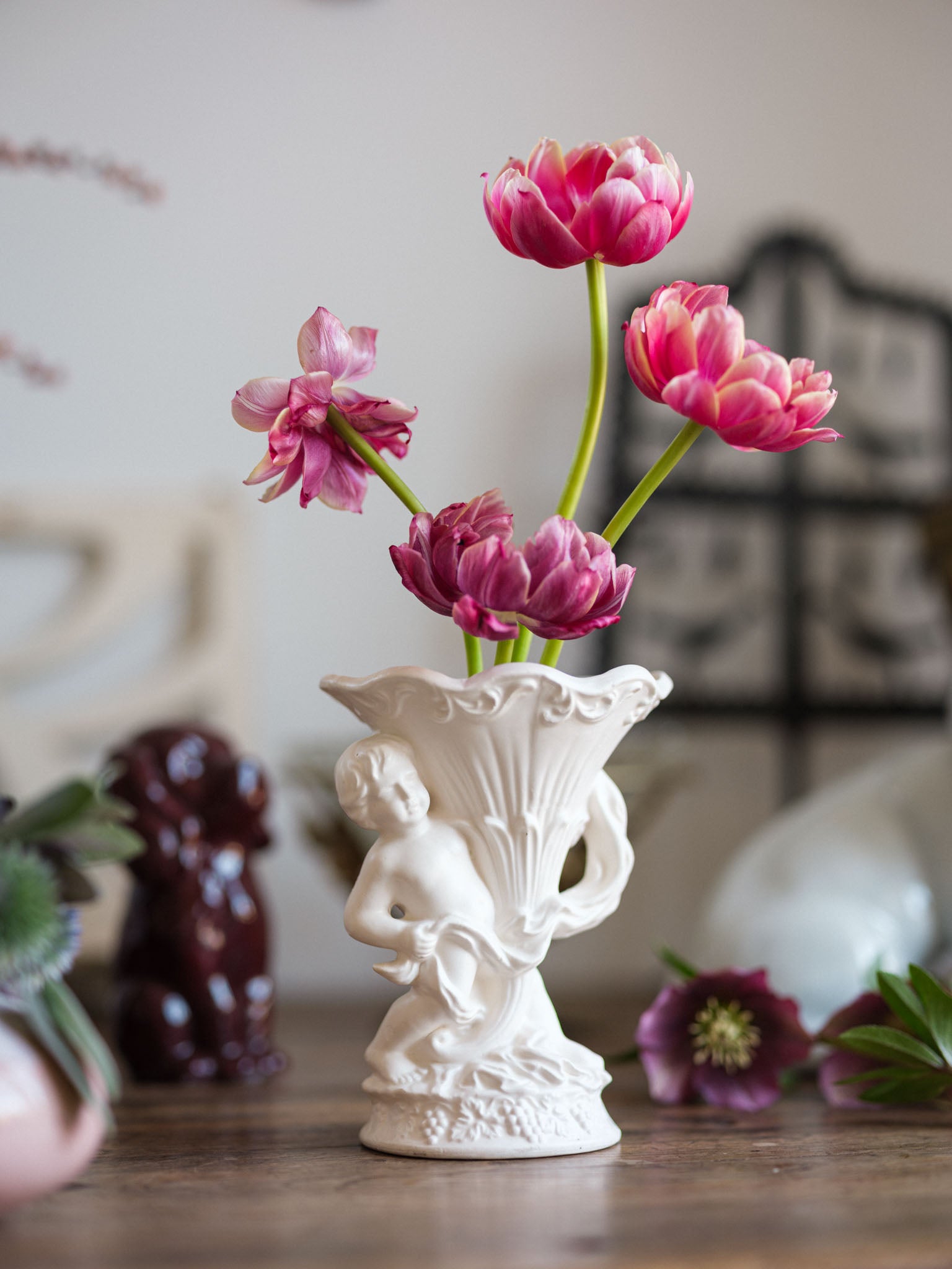 Decorative vase with pink flowers on a wooden surface