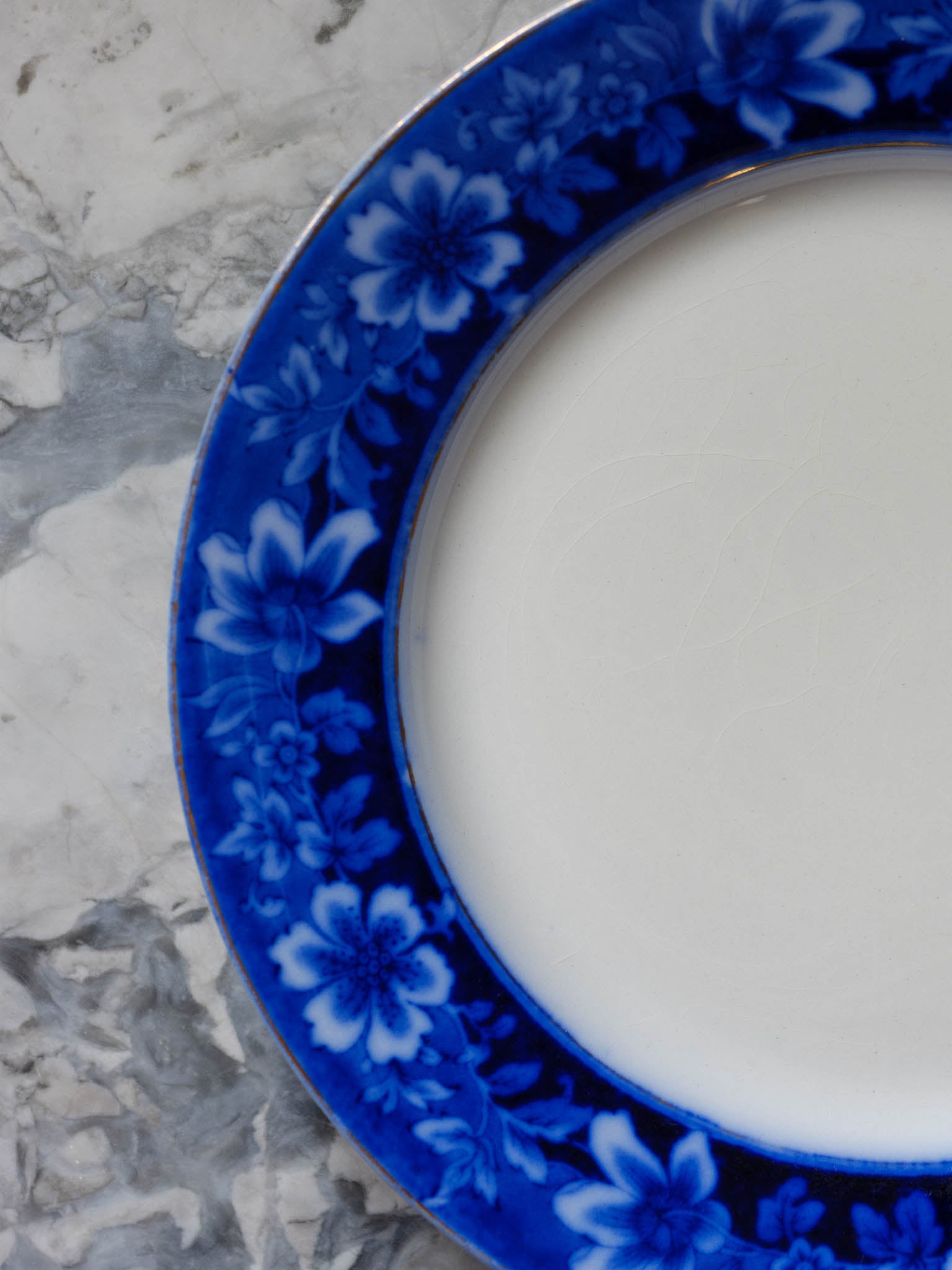 Blue floral-patterned saucer on a marble surface