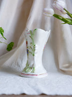 Decorative vase with floral patterns on a white fabric background