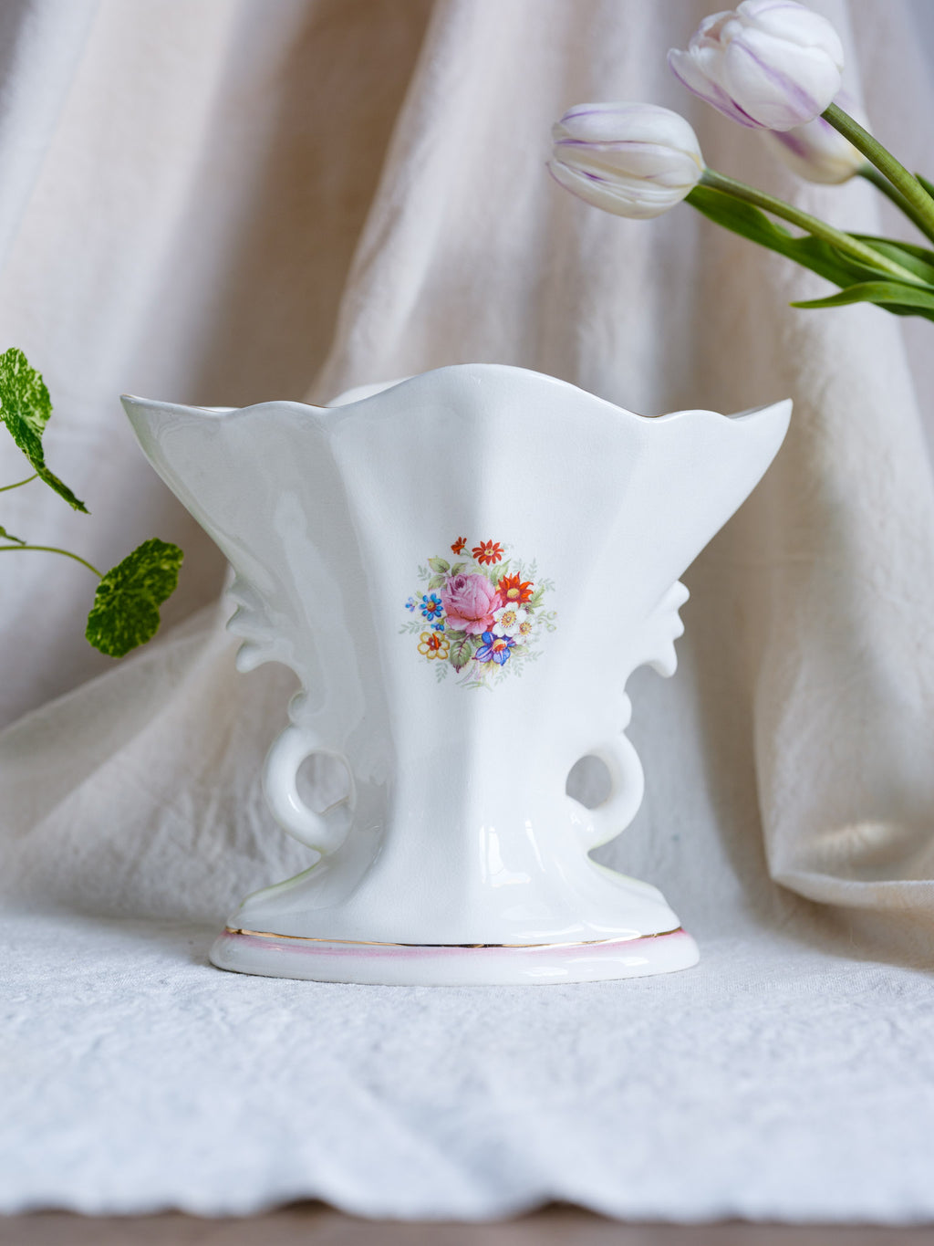 Decorative white vase with floral design on a light background
