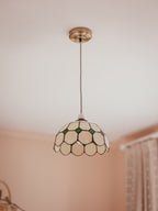 Tiffany-style pendant light with a geometric glass shade in a room setting.