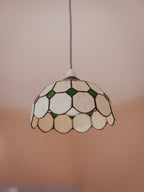 Stained glass pendant light with a geometric pattern on a neutral background