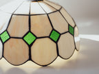 Stained glass lamp with geometric design and green accents on a white background