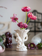 Decorative vase with pink flowers on a wooden surface