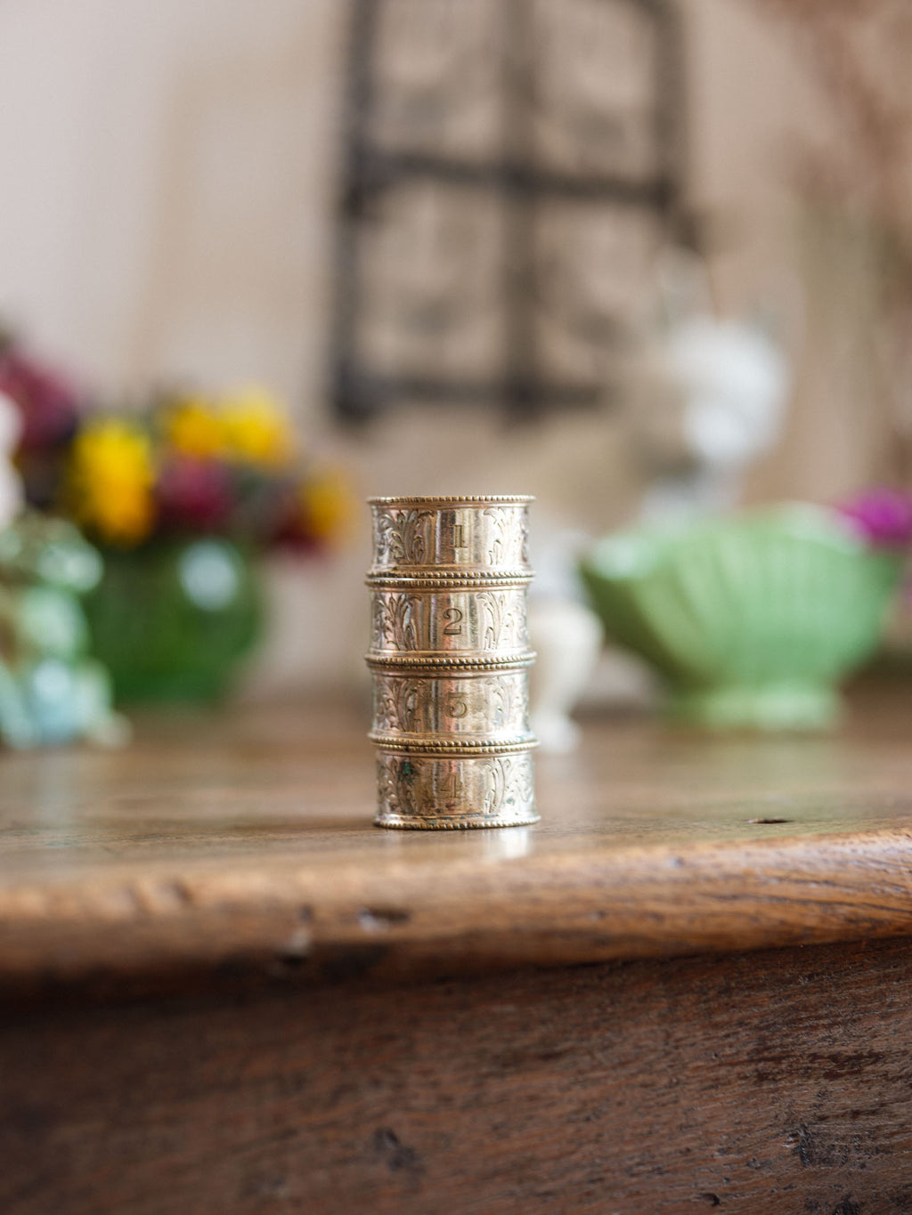Stack of silver rings on a wooden surface with a blurred background