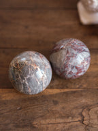 Two marbled stones on a wooden surface