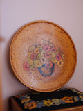 Round ceramic plate with floral design on a plain background