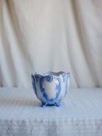 Blue and white ceramic vase on a textured surface with a neutral background