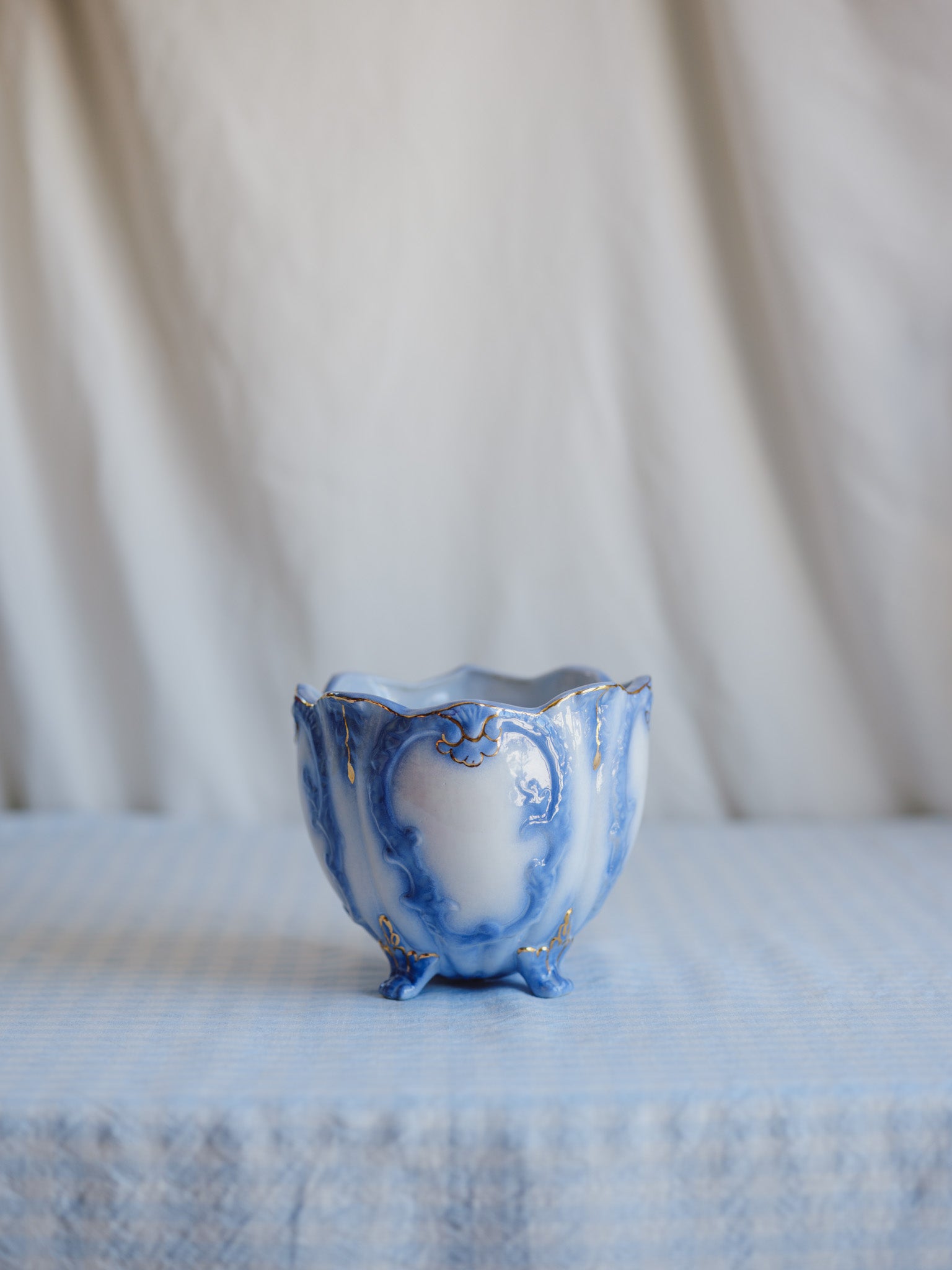 Blue and white ceramic vase on a textured surface with a neutral background