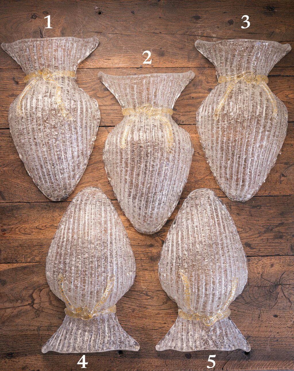 Vintage Murano glass wall sconce with ribbed clear glass and gold ribbon detailing. Italian mid-century wall light, hand-blown using the Graniglia technique. Mounted on a light grey backplate with brass fittings, perfect for hallways, bedrooms, or statement lighting.