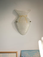 Vintage Murano glass wall sconce with ribbed clear glass and gold ribbon detailing. Italian mid-century wall light, hand-blown using the Graniglia technique. Mounted on a light grey backplate with brass fittings, perfect for hallways, bedrooms, or statement lighting.
