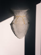 Vintage Murano glass wall sconce with ribbed clear glass and gold ribbon detailing. Italian mid-century wall light, hand-blown using the Graniglia technique. Mounted on a light grey backplate with brass fittings, perfect for hallways, bedrooms, or statement lighting.