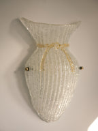 Vintage Murano glass wall sconce with ribbed clear glass and gold ribbon detailing. Italian mid-century wall light, hand-blown using the Graniglia technique. Mounted on a light grey backplate with brass fittings, perfect for hallways, bedrooms, or statement lighting.
