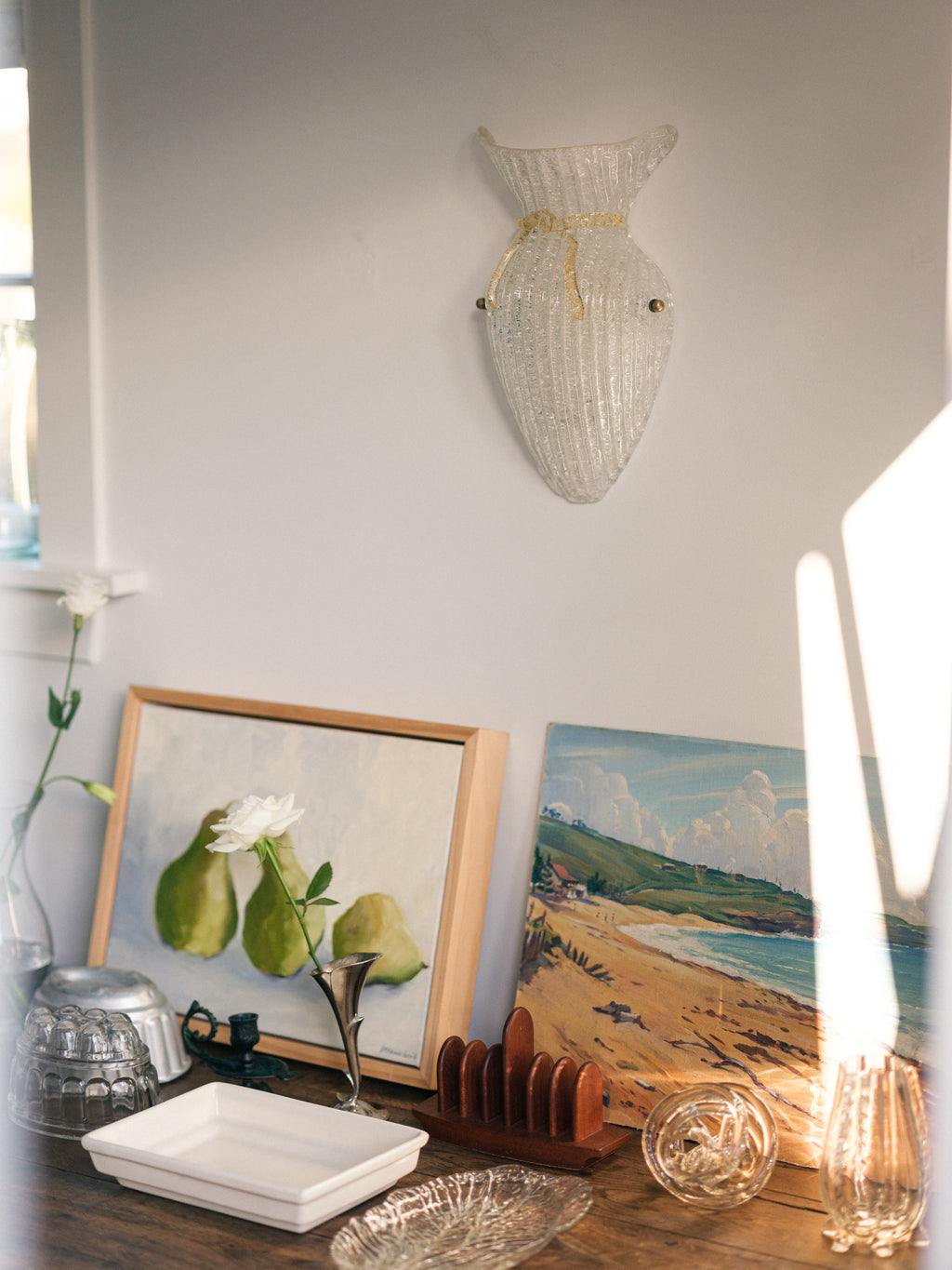 Vintage Murano glass wall sconce with ribbed clear glass and gold ribbon detailing. Italian mid-century wall light, hand-blown using the Graniglia technique. Mounted on a light grey backplate with brass fittings, perfect for hallways, bedrooms, or statement lighting.
